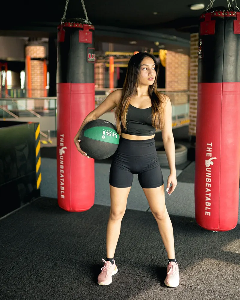 Member holding a medicine ball between punching bags at IronPulse Fitness