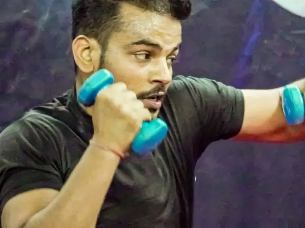 Member punching with light dumbbells in a HIIT session