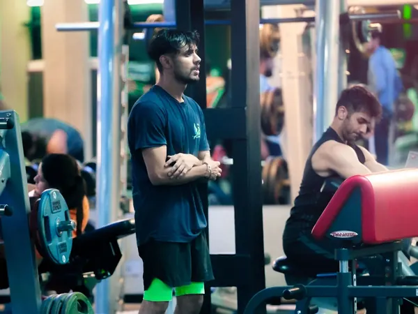 Trainer watching a member on the preacher curl bench