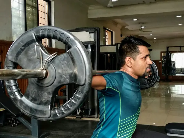 Member doing a barbell lunge on the gym floor